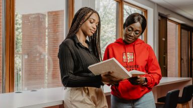 deux étudiantes consultent un livre