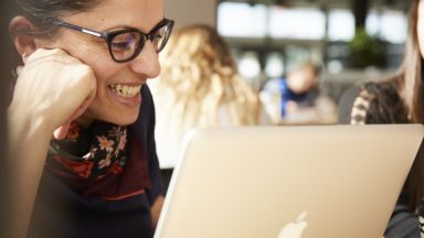 Étudiante sourit devant son ordinateur